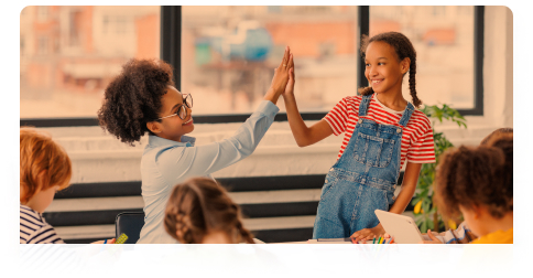 Teacher and student sharing a high-five in a classroom for Acadience Reading Diagnostic