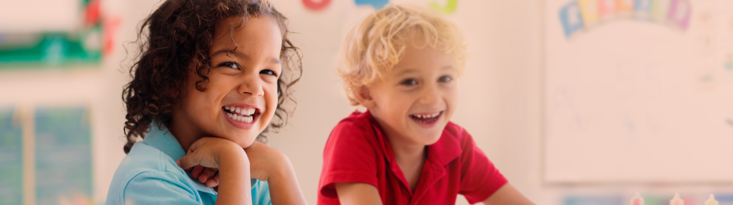 Two children laughing in a classroom