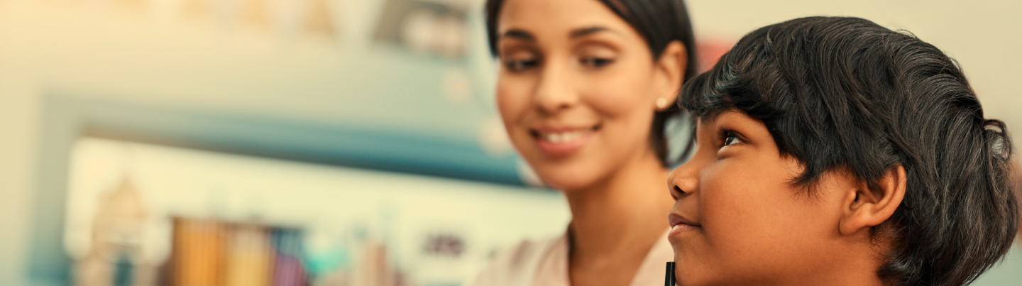 Student solving a problem while teacher observes