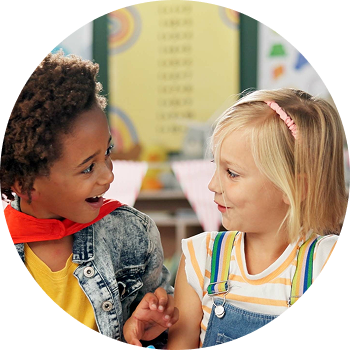 Two students smiling at each other in a Acadience Spelling workshop