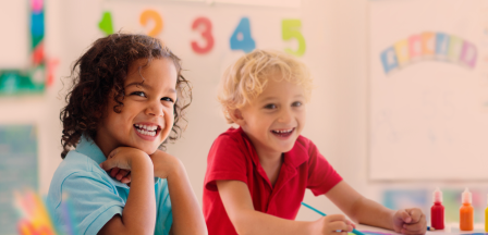 Two children laughing in a classroom